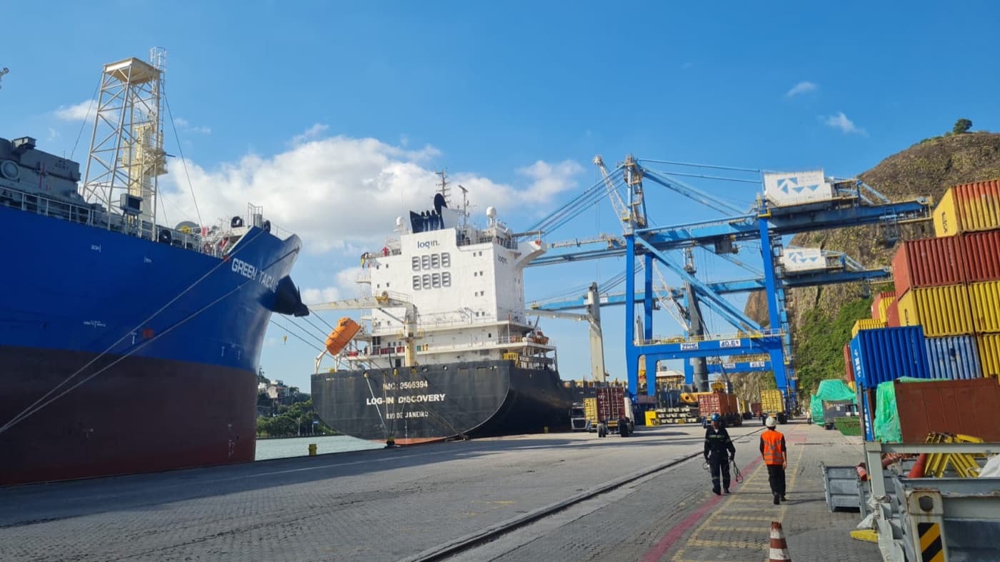 Equipe da Clean Ship no cais entre navios atracados sob pórticos portuários